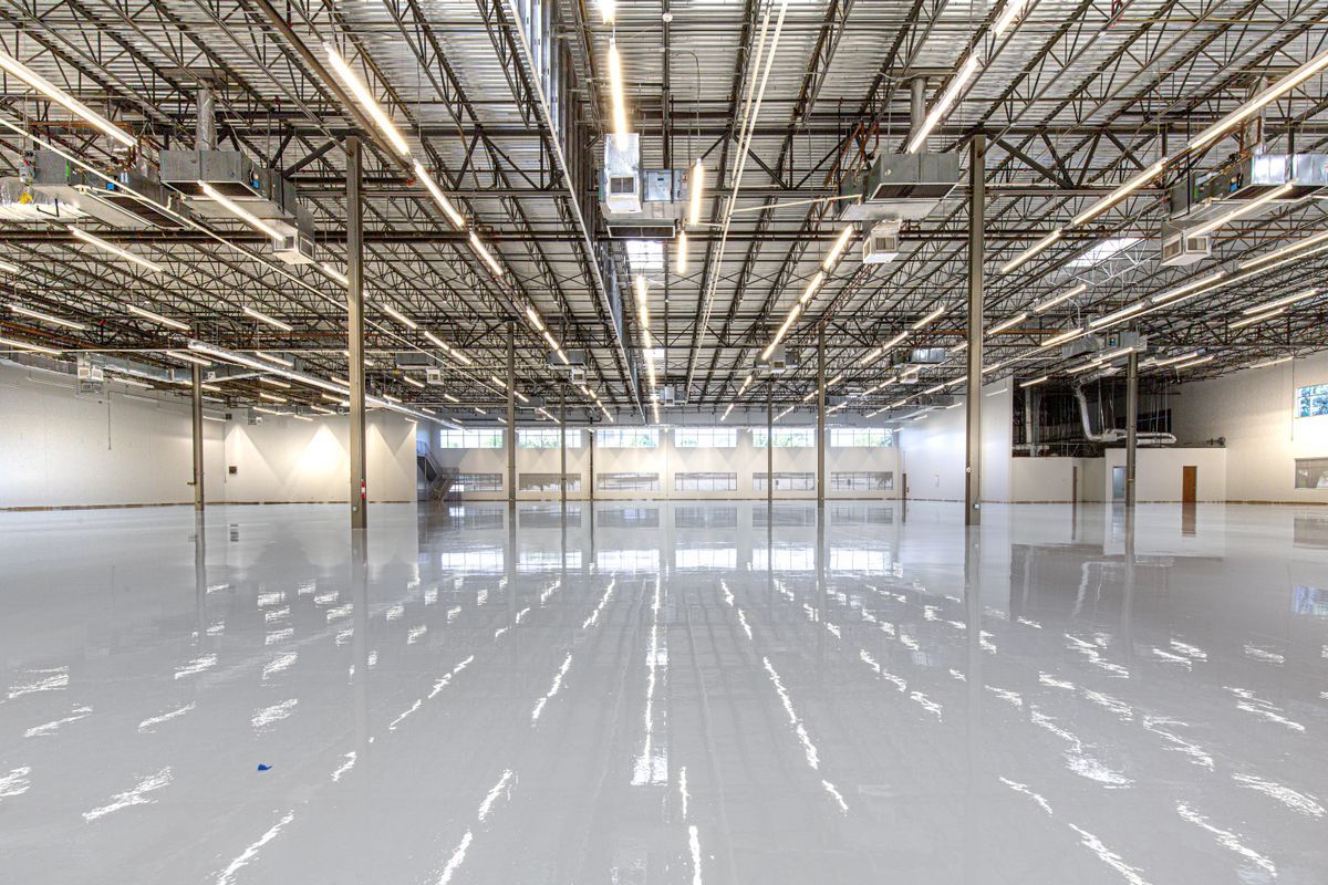High-gloss light gray epoxy floor reflecting the lights of a large commercial space