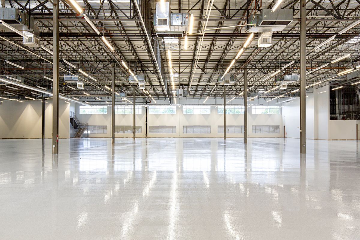 Polished light-colored coated floor inside a large empty warehouse